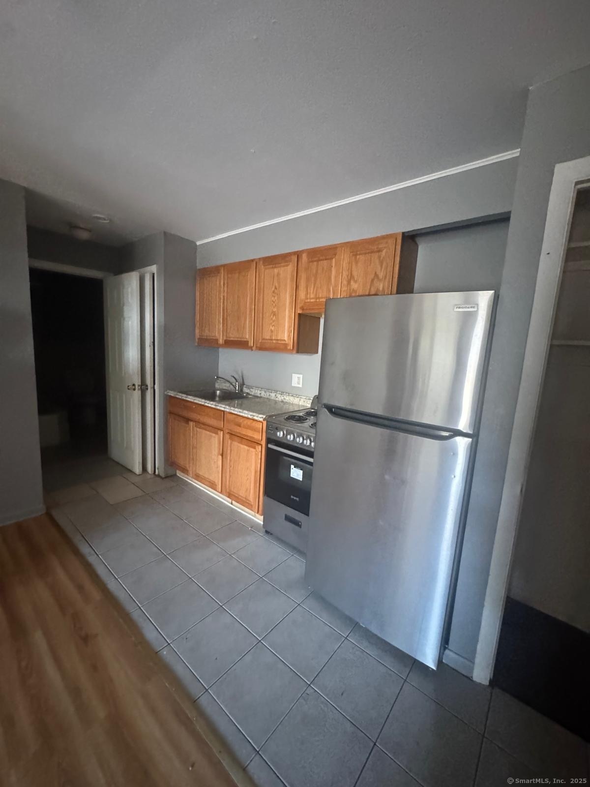 240 Oak Street, Unit 3 Bridgeport, CT 06604 - Photo 3 of 8 a kitchen with stainless steel appliances granite countertop a refrigerator and a sink