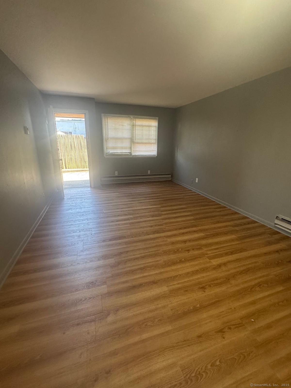 240 Oak Street, Unit 3 Bridgeport, CT 06604 - Photo 4 of 8 wooden floor in an empty room with a window