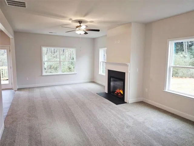 a view of an empty room with window and fire place