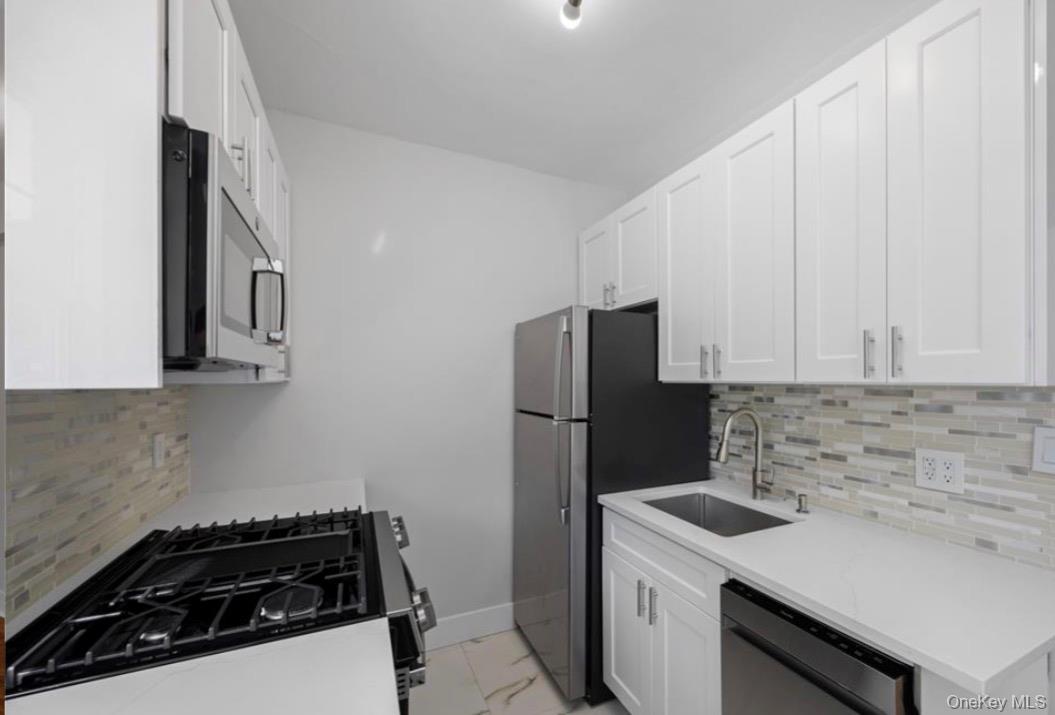 230 Pelham Road, Unit 1O New Rochelle, NY 10805 - Photo 4 of 29 a kitchen with a sink stove and refrigerator