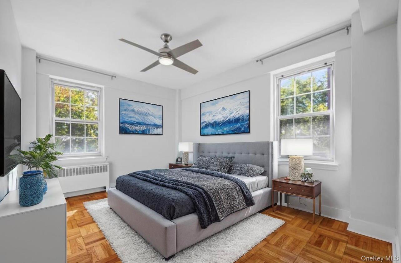 230 Pelham Road, Unit 1O New Rochelle, NY 10805 - Photo 7 of 29 a bedroom with a bed lamp and a potted plant