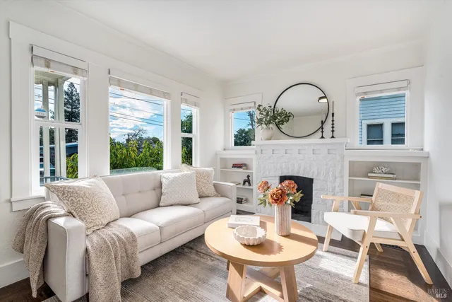 a living room with furniture a fireplace and a large window
