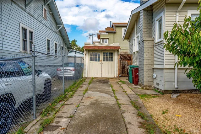 a view of a white house next to a yard