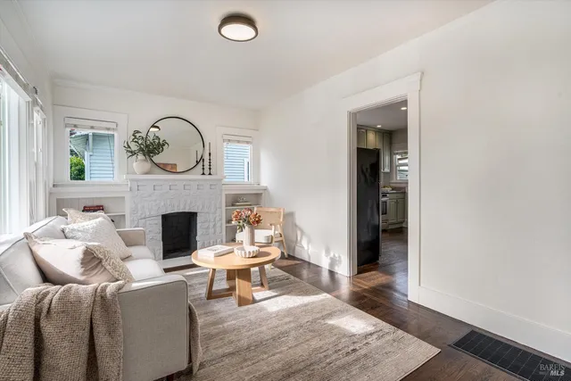 a living room with furniture a fireplace and a large window