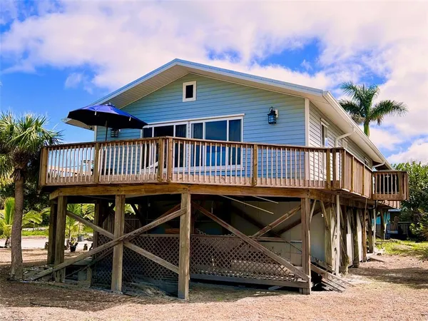 a view of a house with wooden deck front of house