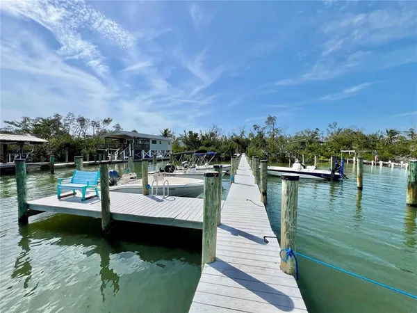 a view of a patio with wooden floor a barbeque grill with dining table and chairs