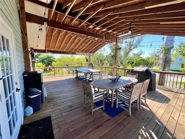 a kitchen with stainless steel appliances kitchen island granite countertop a refrigerator a stove top oven a sink dishwasher and a dining table with wooden floor