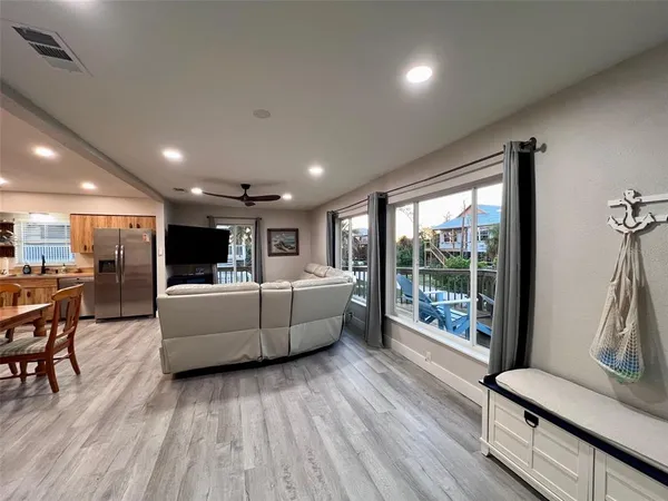a living room with furniture and view of kitchen