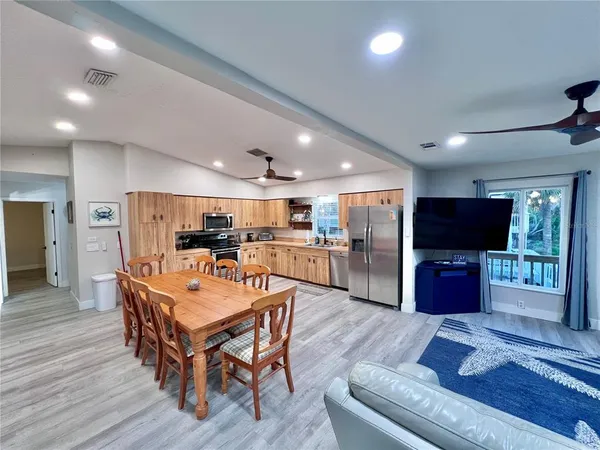 a kitchen with stainless steel appliances granite countertop a refrigerator a stove top oven a sink dishwasher and wooden cabinets