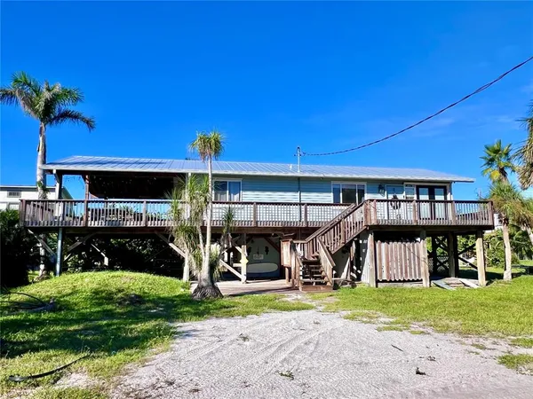a view of a house with a yard and potted plants