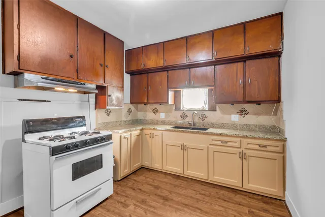 a kitchen with stainless steel appliances granite countertop wooden cabinets stove top oven and sink
