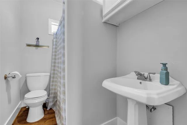 a bathroom with a toilet sink and mirror