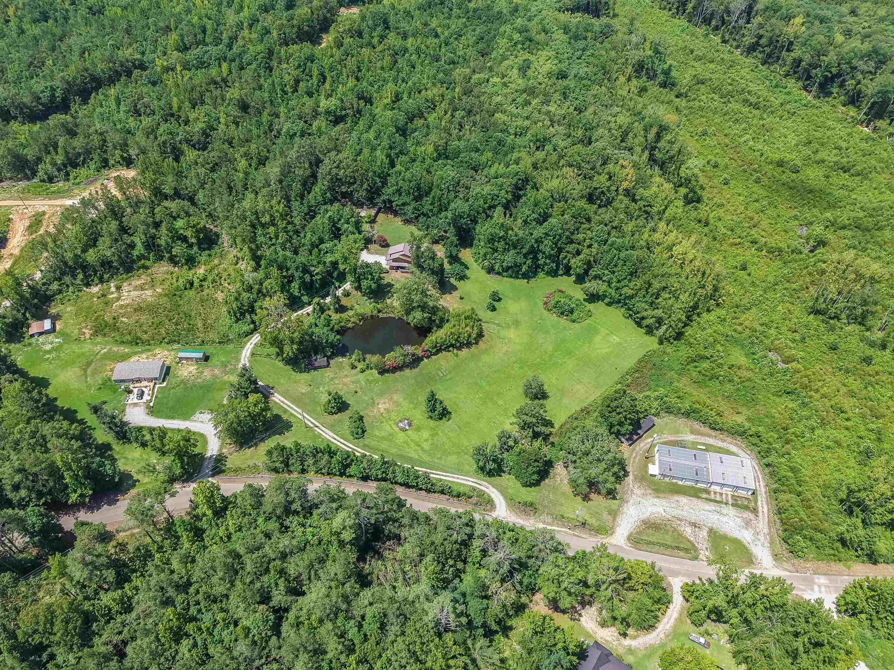 2380 Dunaway Road Selmer, TN 38375 - Photo 3 of 39 Expansive wooded acreage featuring a private pond, multiple outbuildings, and a main residence