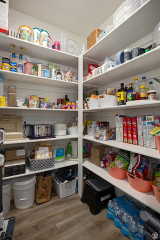 983 South 950 West Provo, UT 84601 - Photo 14 of 56 Spacious pantry featuring extensive built-in shelving, durable wood-finish flooring, and bright overhead lighting