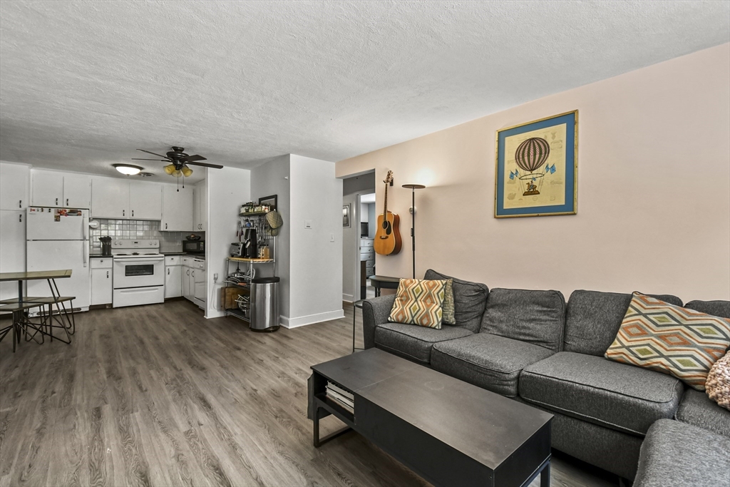 1105 Lexington Street, Unit 102 Waltham, MA 02452 - Photo 12 of 41 a living room with furniture and kitchen view