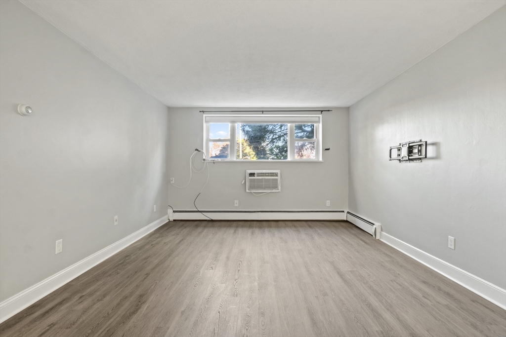 1105 Lexington Street, Unit 102 Waltham, MA 02452 - Photo 14 of 41 an empty room with wooden floor and windows