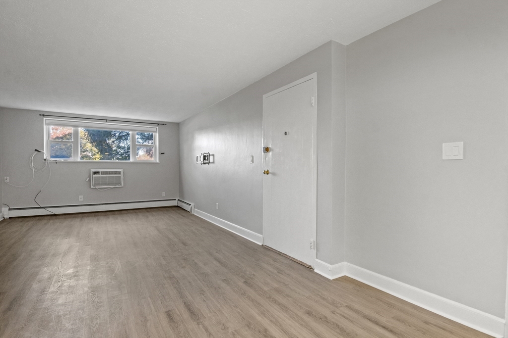 1105 Lexington Street, Unit 102 Waltham, MA 02452 - Photo 15 of 41 an empty room with wooden floor and window