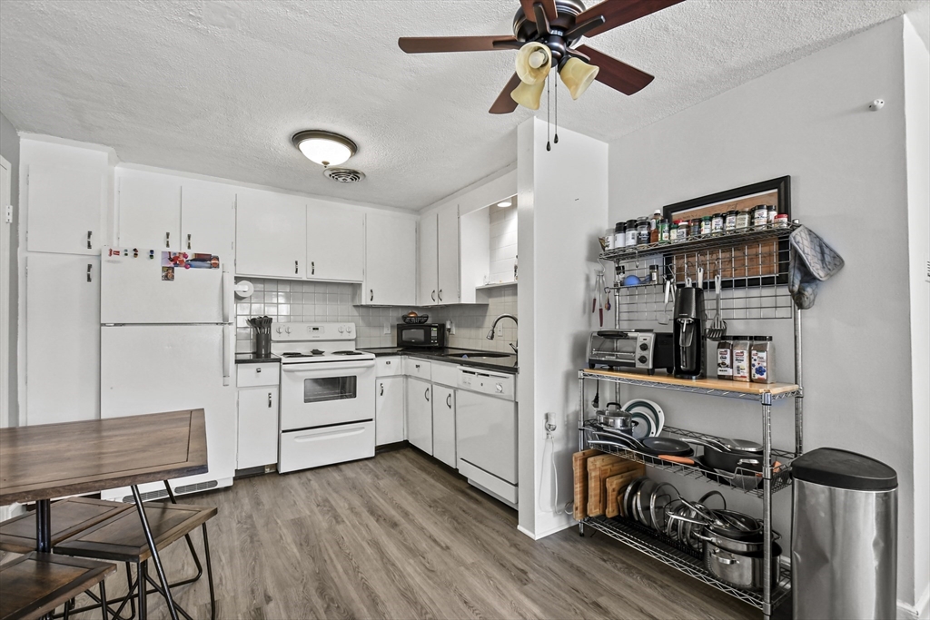 1105 Lexington Street, Unit 102 Waltham, MA 02452 - Photo 19 of 41 a kitchen with stainless steel appliances a stove a refrigerator and white cabinets