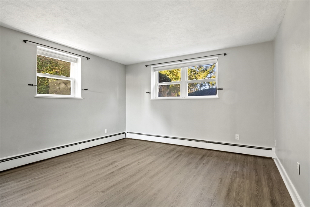 1105 Lexington Street, Unit 102 Waltham, MA 02452 - Photo 22 of 41 an empty room with wooden floor and window