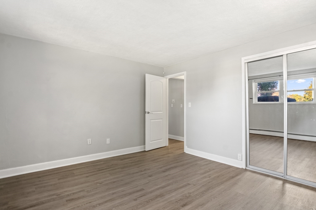 1105 Lexington Street, Unit 102 Waltham, MA 02452 - Photo 24 of 41 an empty room with wooden floor & closet and windows