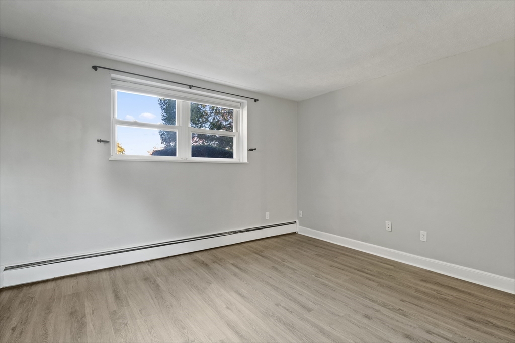 1105 Lexington Street, Unit 102 Waltham, MA 02452 - Photo 25 of 41 wooden floor in an empty room with a window