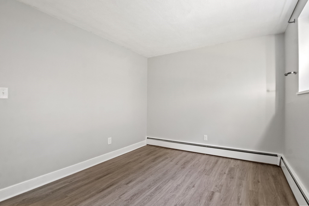 1105 Lexington Street, Unit 102 Waltham, MA 02452 - Photo 29 of 41 a view of an empty room with wooden floor