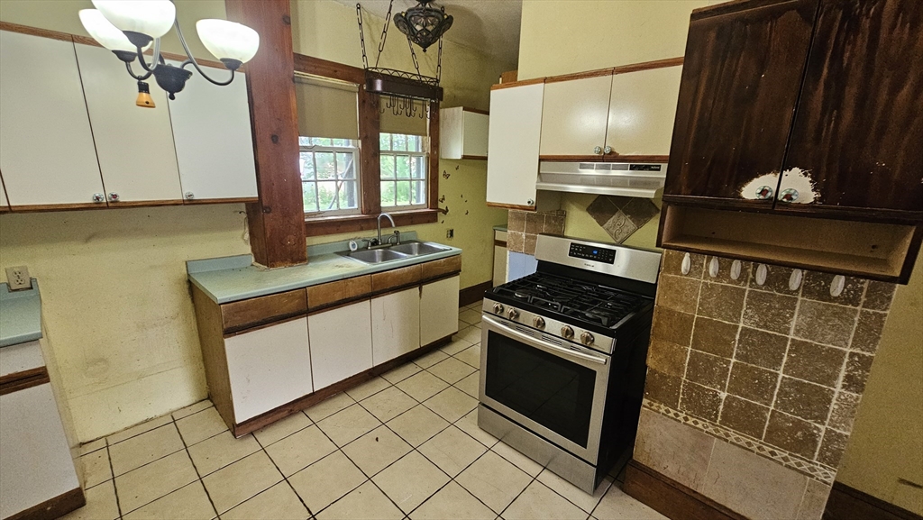 179 Oak Street Springfield, MA 01151 - Photo 14 of 28 a kitchen with granite countertop a stove a sink and a microwave