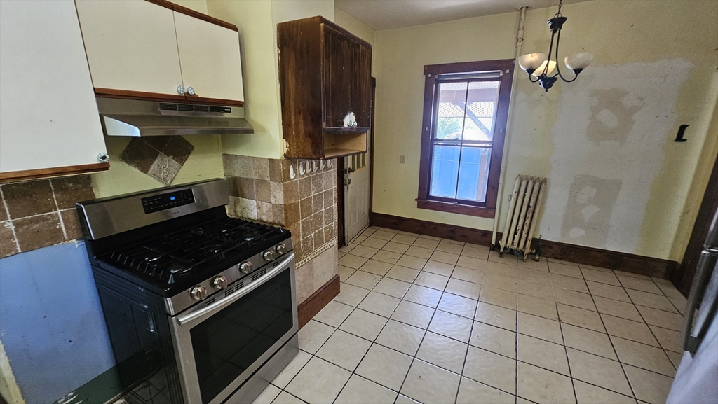 179 Oak Street Springfield, MA 01151 - Photo 16 of 28 a kitchen with granite countertop a stove a sink and a refrigerator