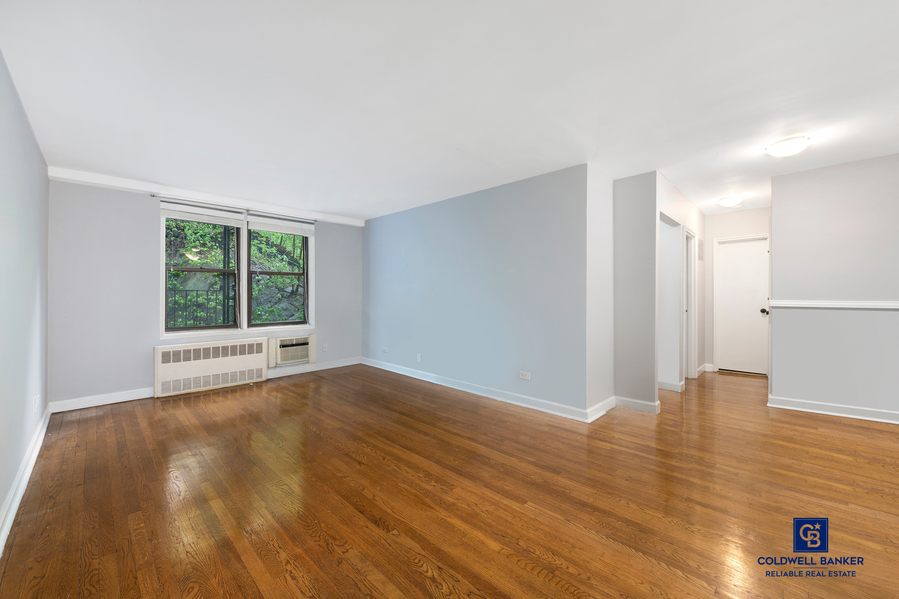 5235 Post Road, Unit 2C Bronx, NY 10471 - Photo 2 of 10 a view of an empty room with wooden floor and a window