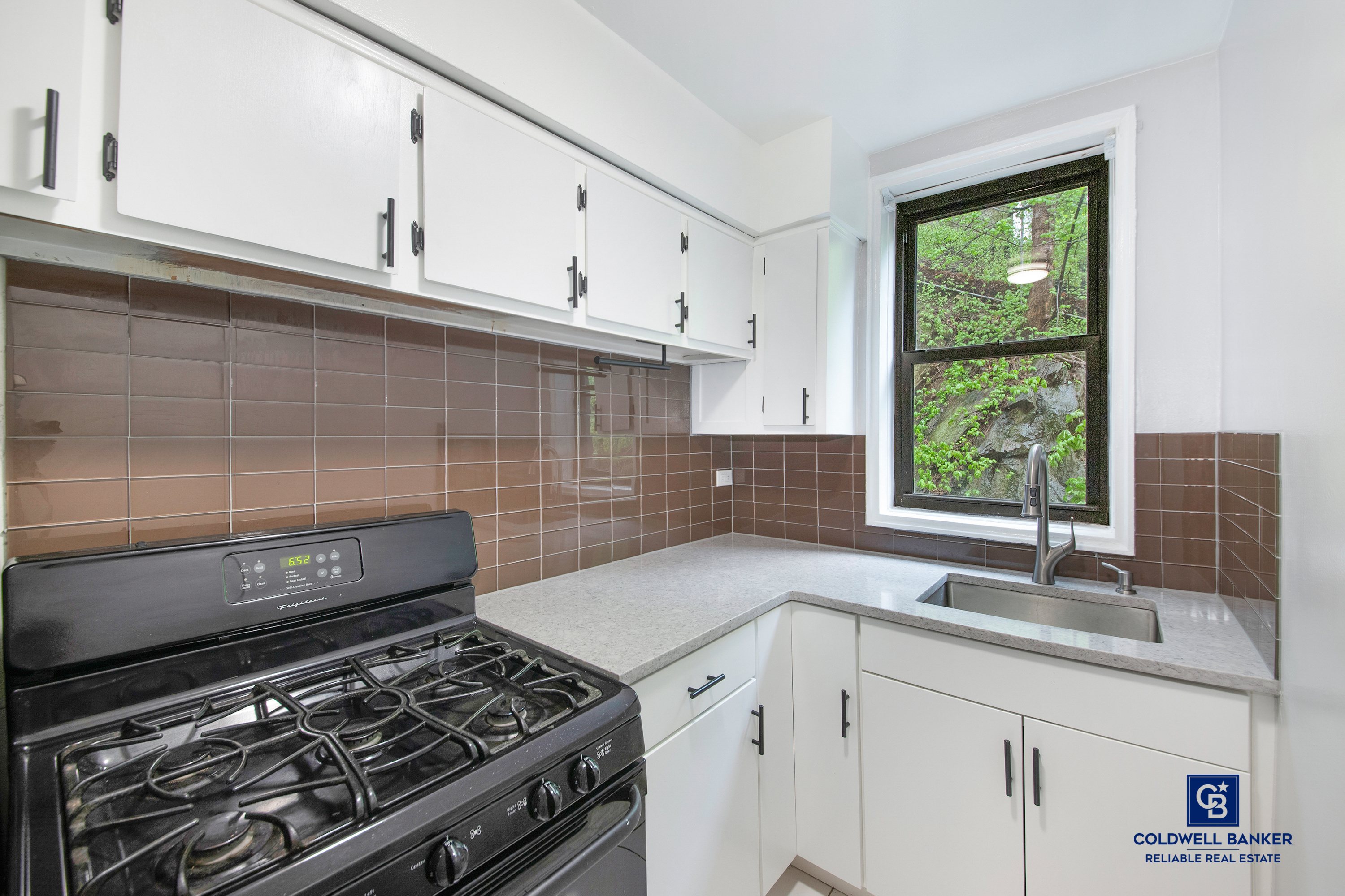 5235 Post Road, Unit 2C Bronx, NY 10471 - Photo 5 of 10 a kitchen with granite countertop a stove sink and cabinets