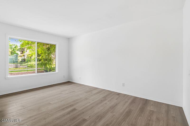 584 Rio Grande Circle Thousand Oaks, CA 91360 - Photo 10 of 19 an empty room with wooden floor and windows