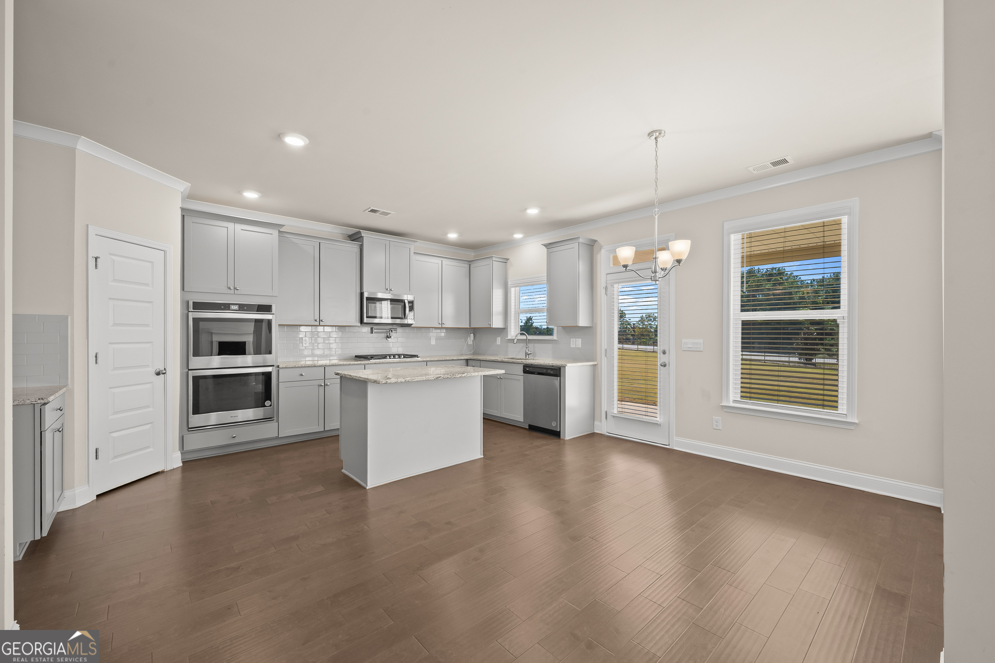 324 Conley Avenue Hampton, GA 30228 - Photo 14 of 59 a kitchen with white cabinets and stainless steel appliances