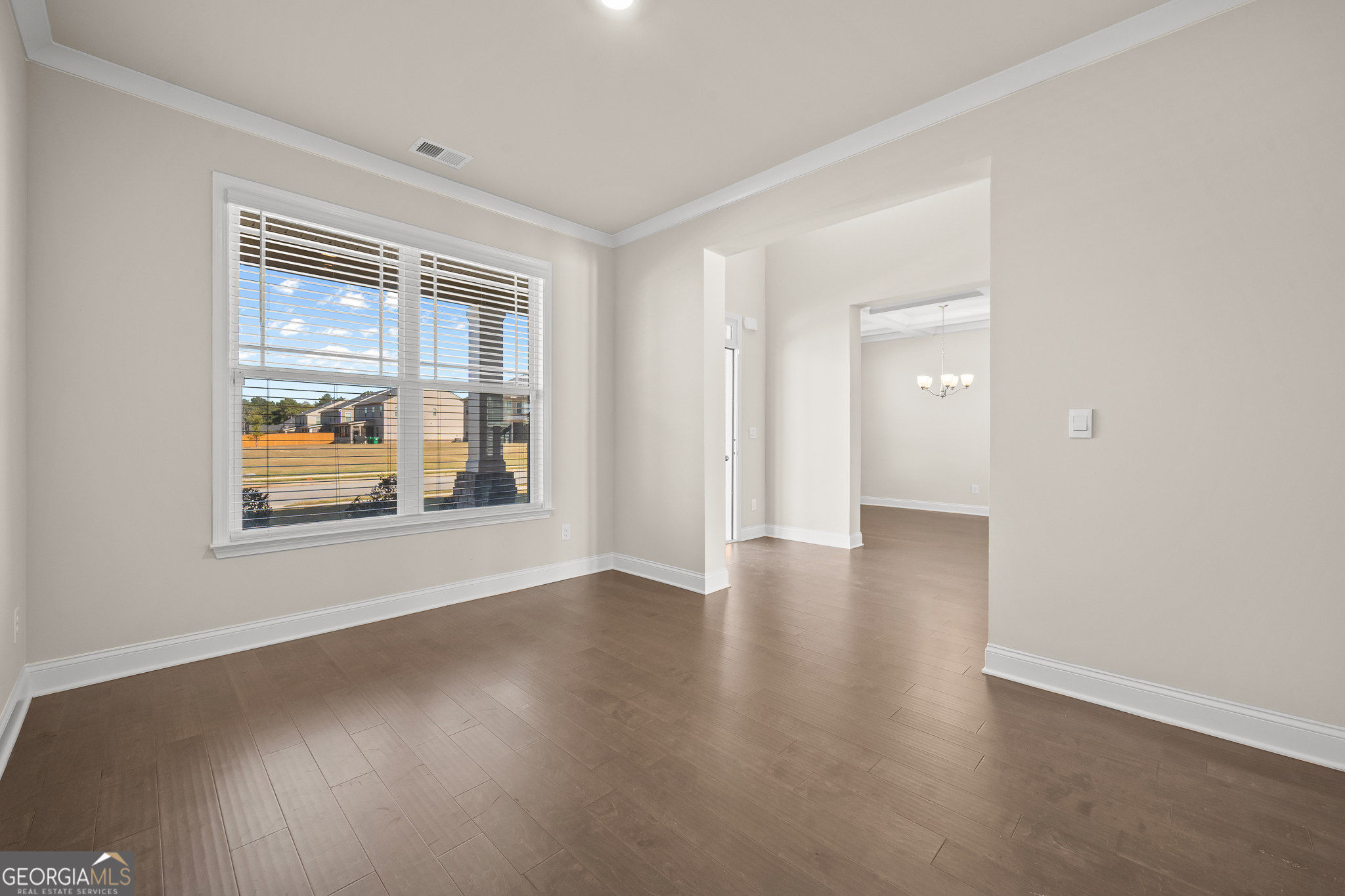 324 Conley Avenue Hampton, GA 30228 - Photo 6 of 59 a view of an empty room with a window and wooden floor