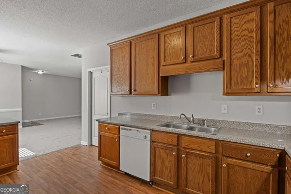 a kitchen with stainless steel appliances granite countertop a sink a cabinets and wooden floor