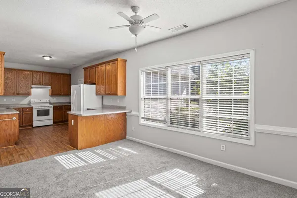 a kitchen with stainless steel appliances granite countertop a stove a sink dishwasher and a refrigerator with wooden floor