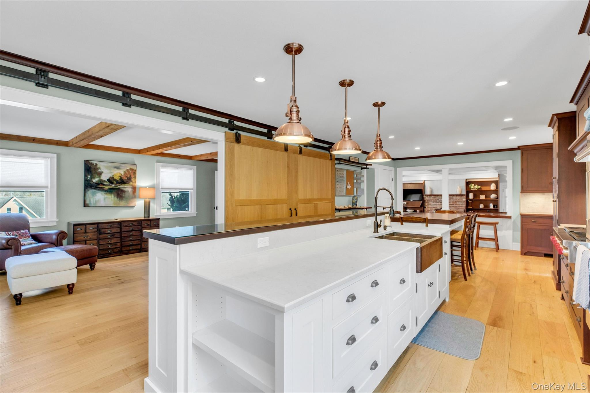 345 Colonial Road Southold, NY 11971 - Photo 43 of 43 a large white kitchen with kitchen island a stove a refrigerator a dining table and chairs with wooden floor