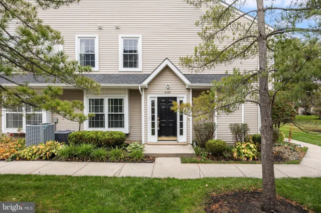 a front view of a house with a yard and potted plants