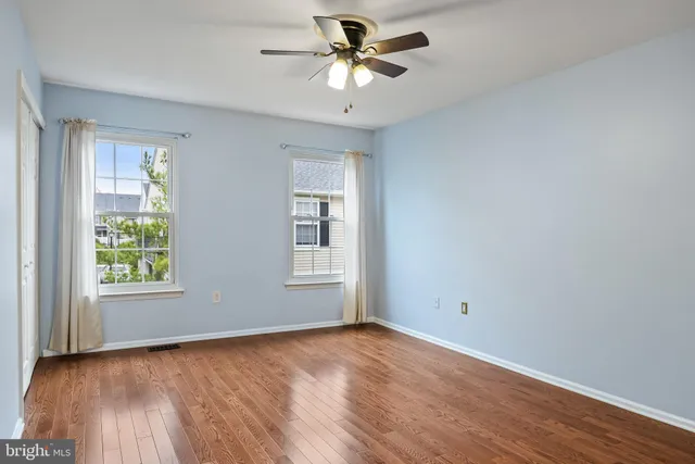 an empty room with a window and a ceiling fan