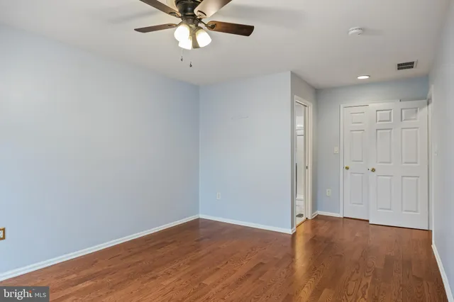 a view of a room with wooden floor and a ceiling fan