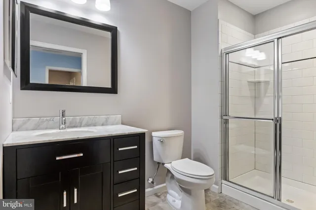 a bathroom with a toilet a sink and mirror