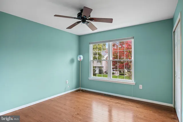 a view of empty room with window and ceiling fan