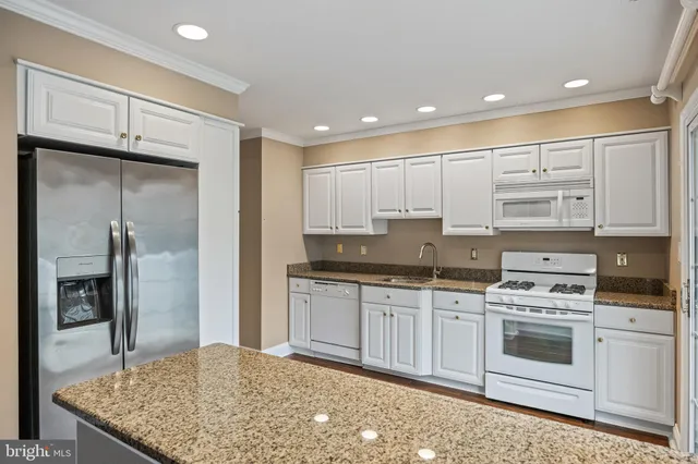 a kitchen with stainless steel appliances granite countertop a stove a sink and a refrigerator