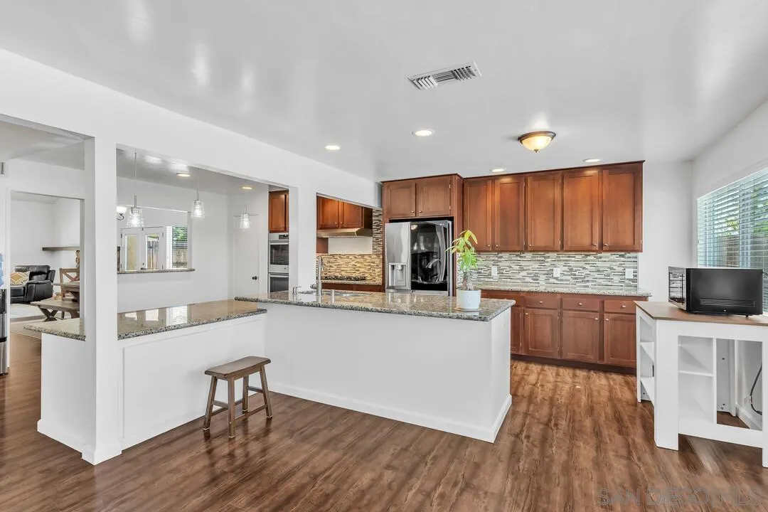1509 Honey Hill Road El Cajon, CA 92020 - Photo 15 of 49 a large kitchen with cabinets wooden floor and stainless steel appliances