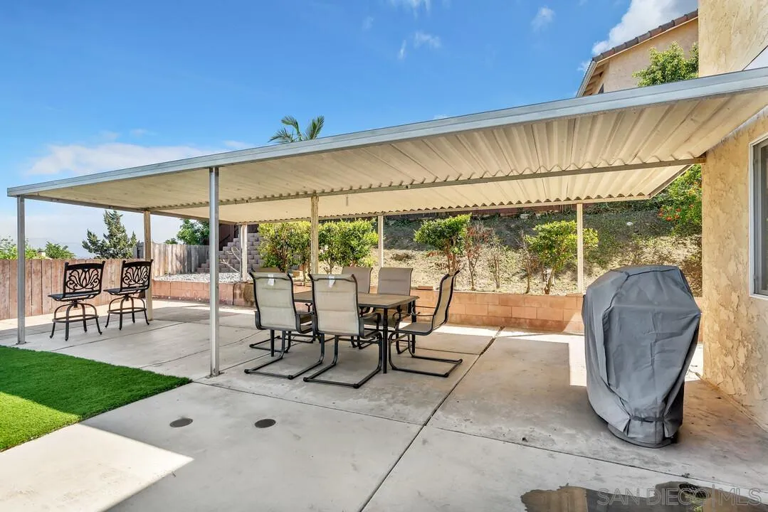 1509 Honey Hill Road El Cajon, CA 92020 - Photo 42 of 49 a view of a patio with table and chairs under an umbrella with a big yard