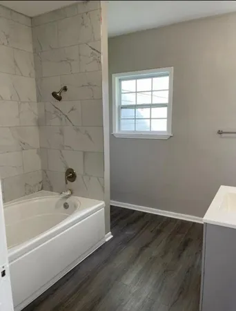 a white bath tub sitting in a bathroom next to a window