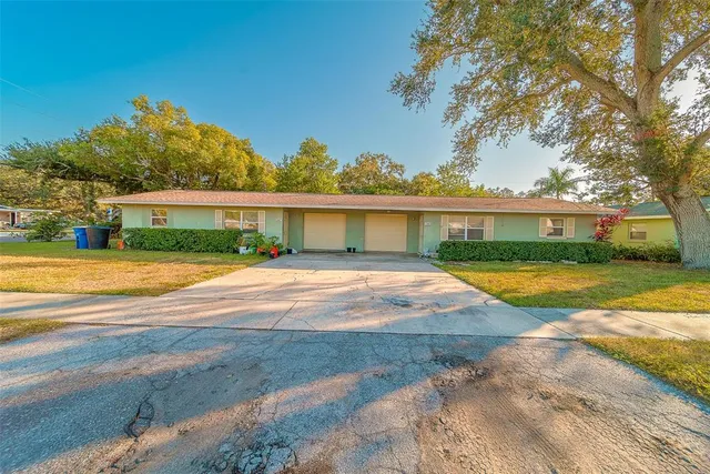 a view of house with swimming pool and a yard