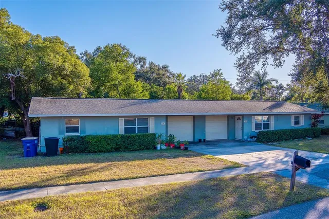 a front view of a house with a yard and trees