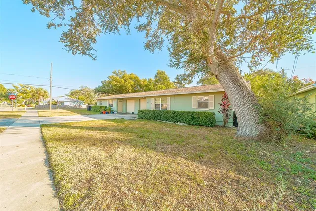 a front view of a house with a yard and trees