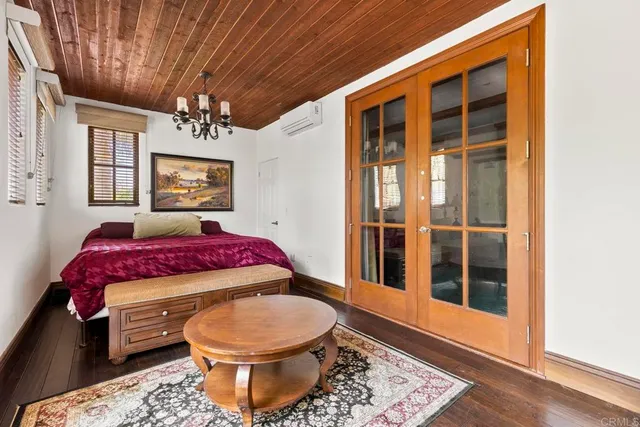 a spacious bedroom with a bed and wooden floor