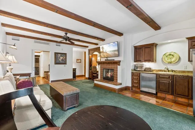 a living room with stainless steel appliances granite countertop furniture and a fireplace